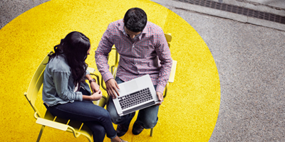 Two people over a laptop